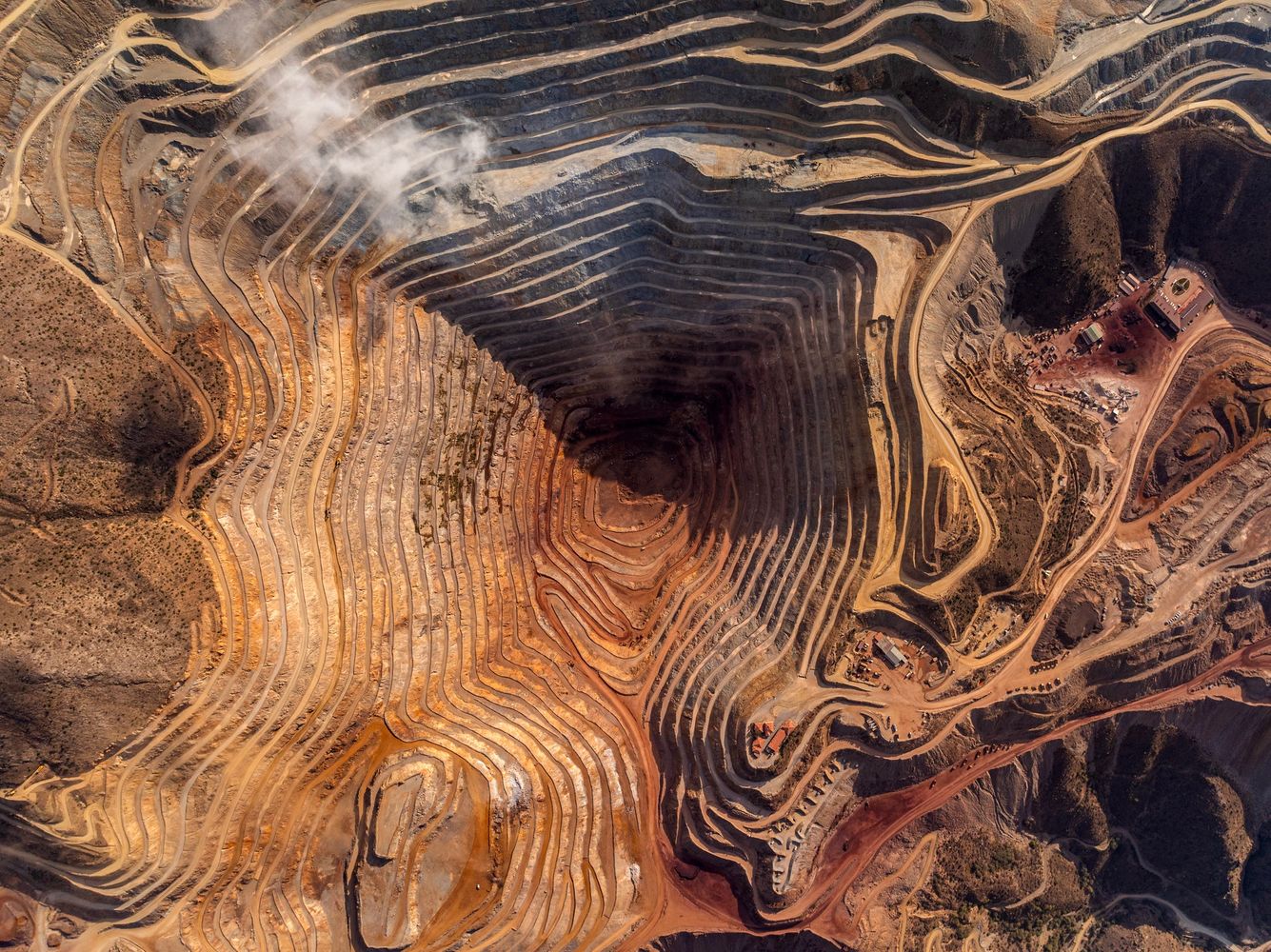 Aerial view of a large open-pit mine with terraced excavation.