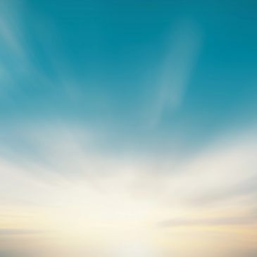 Bright blue sky with soft clouds and sunlight.