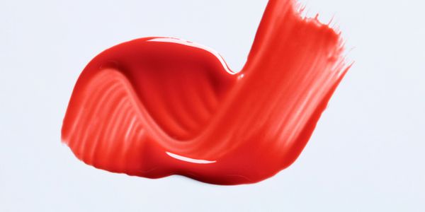 Smooth red paint stroke on a light background.