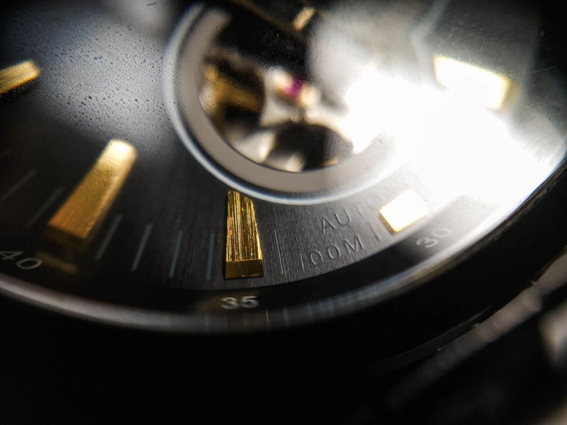 Close up gold plated hour markers on a mechanical analog watch