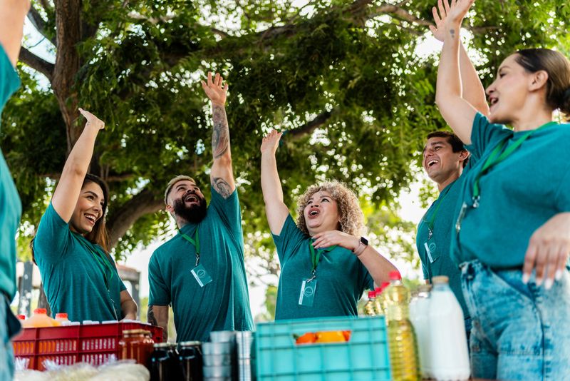 Volunteers with hands raised outdoors