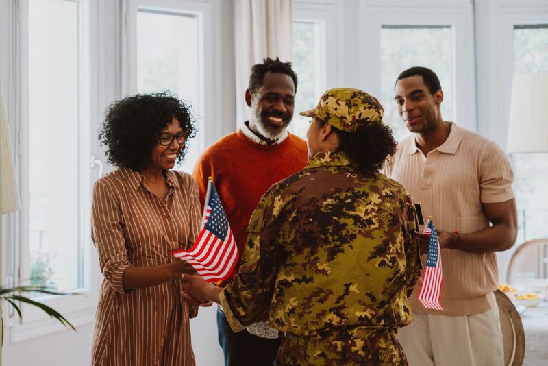 Us Veteran woman homecoming. Young woman coming back to her family from military service for holidays. Female soldier going back home to spend time with relatives.