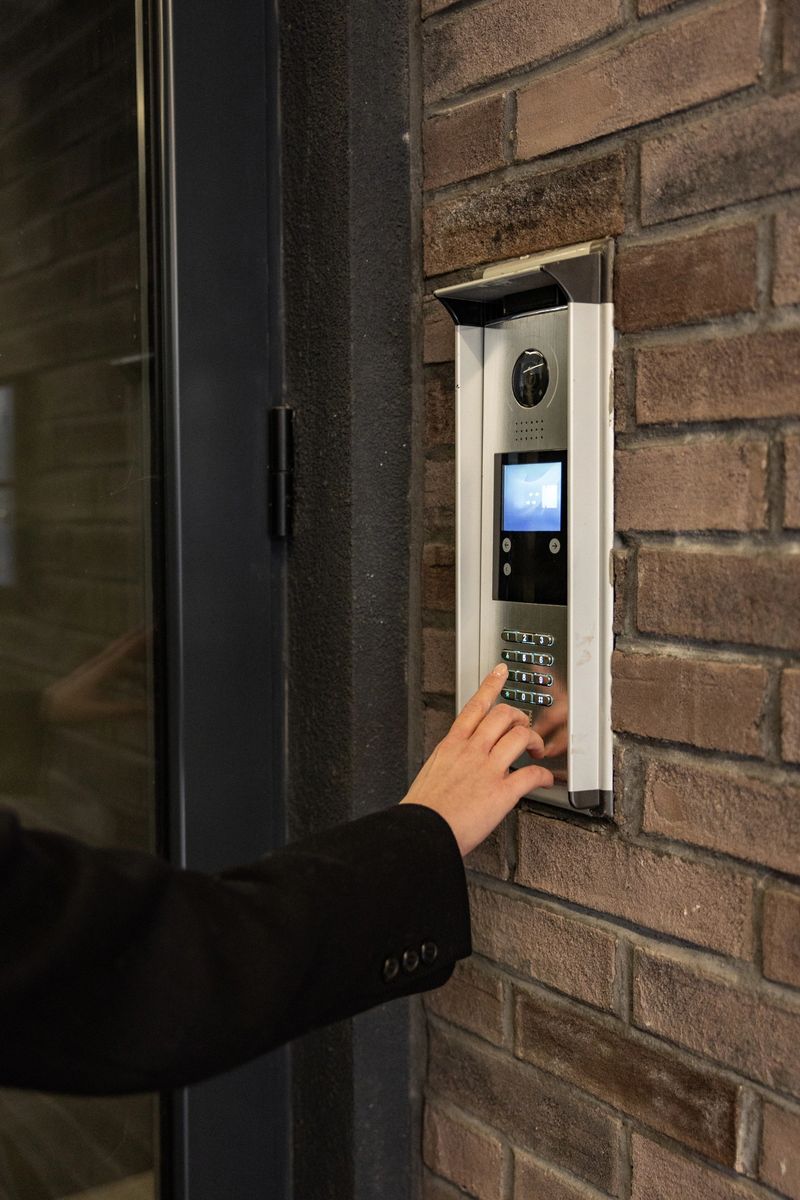Close-up shot of male hand putting code in alarm system panel at home