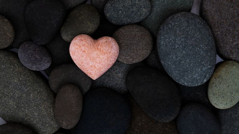 Pink stone heart in a stone heap
