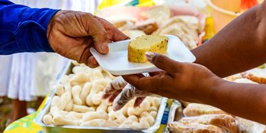 A man serving food on a plate to an elderly man