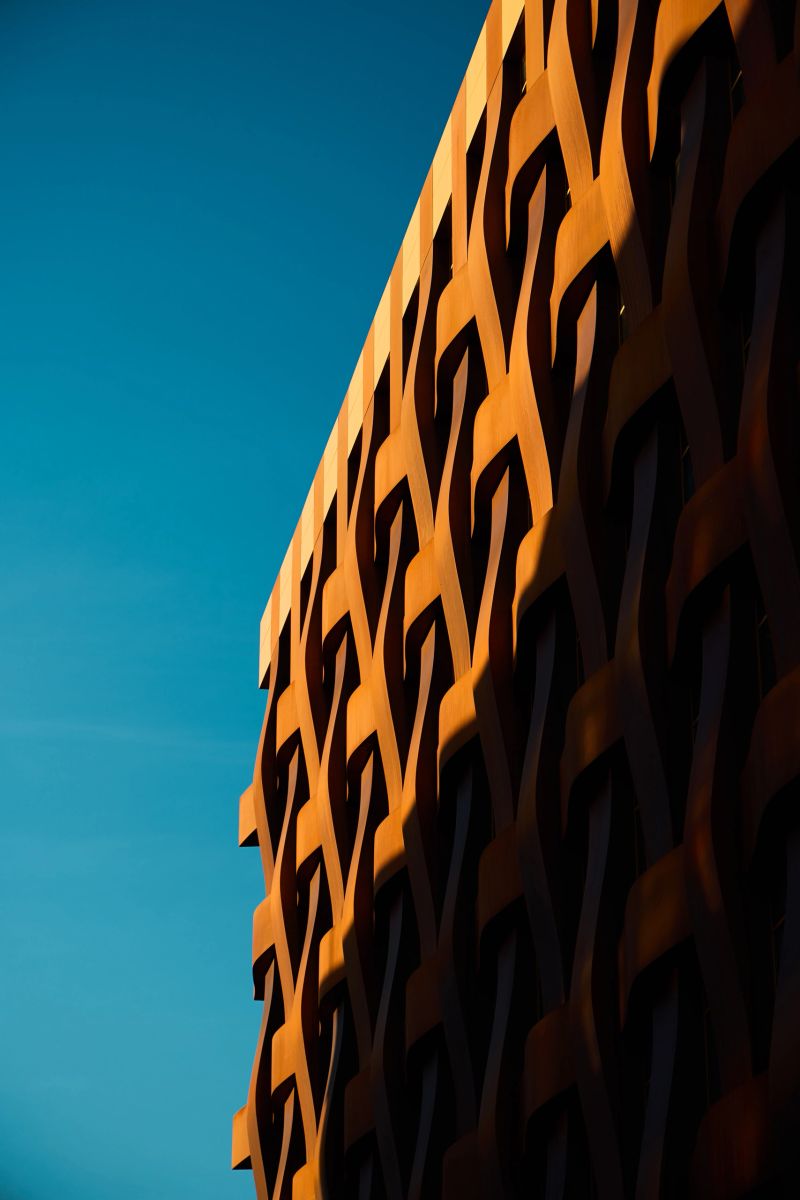 This artistic view features a fascinating perspective of a unique building facade that casts interesting shadows