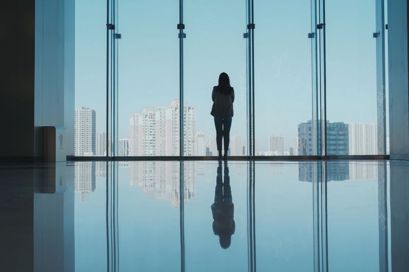 Businesswomen Standing Near The Window Looking City Skyline