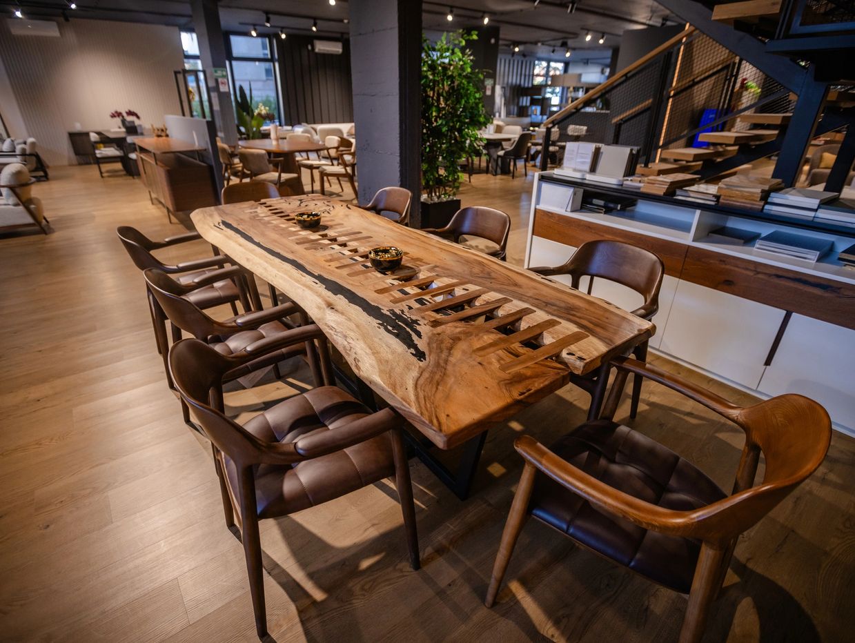 Elegant wooden table with leather chairs in a modern showroom.