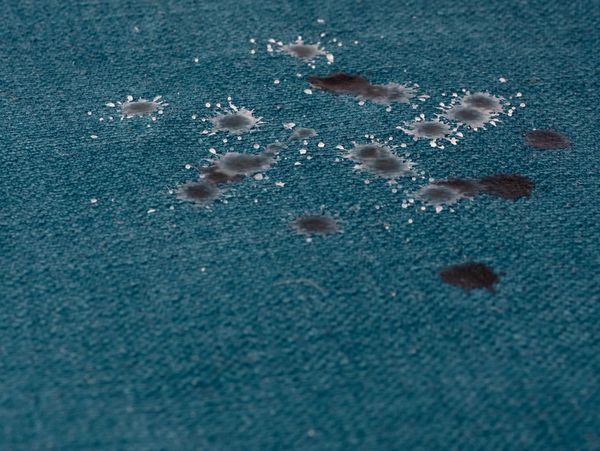 Water droplets splashed on a blue fabric surface.