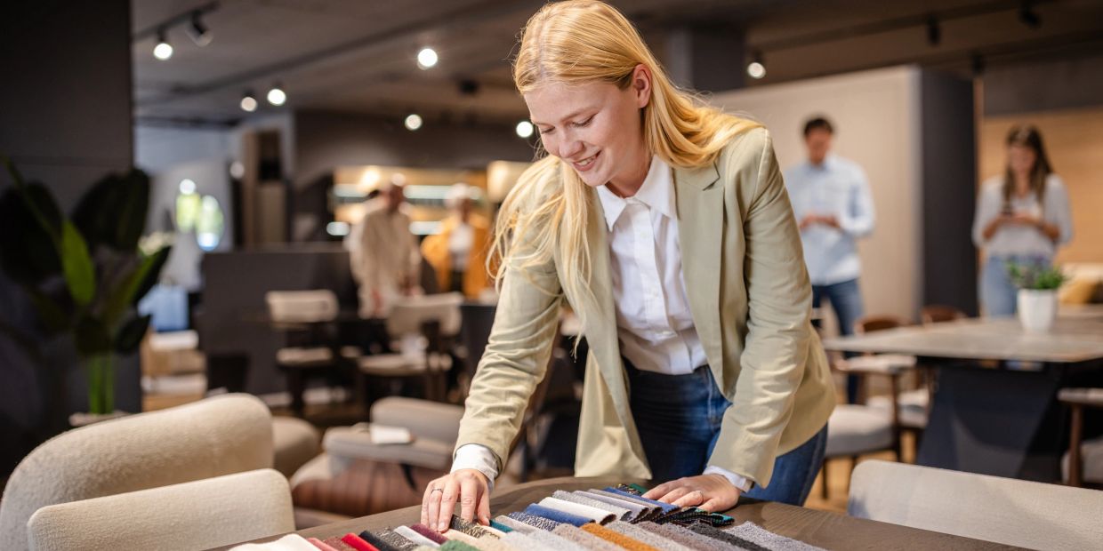 Woman examining fabric samples at a showroom.