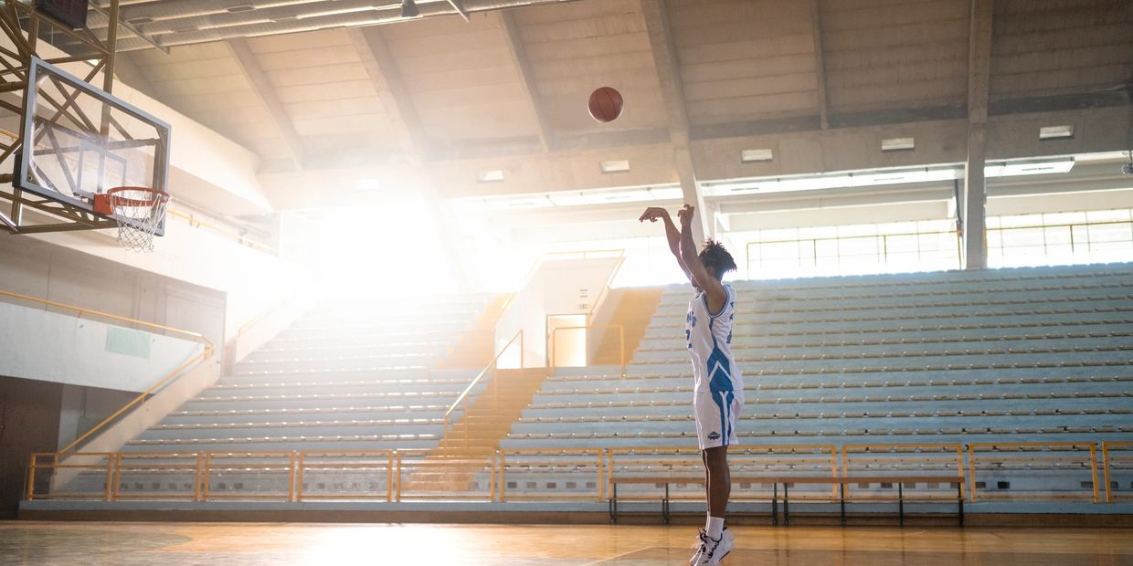 man shooting baskets at Indoor basketball court