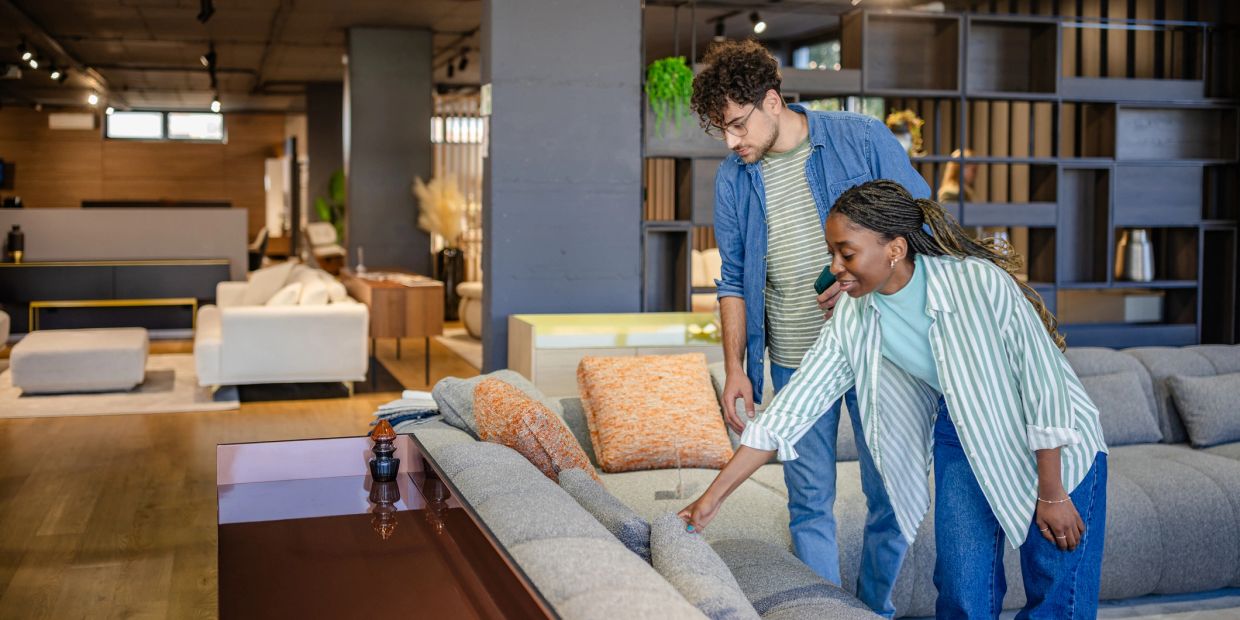 Couple inspecting a sofa in a modern furniture store.