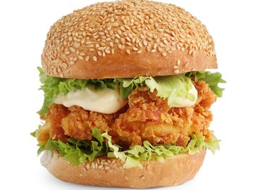 Crispy fried chicken sandwich with lettuce and mayonnaise on a sesame bun.
