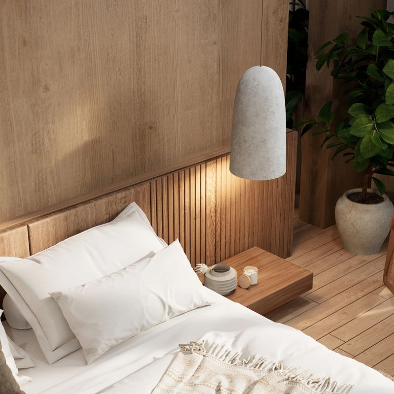 A cozy, modern bedroom featuring a wooden headboard, soft linens, a stylish pendant light, and indoor plants for a warm, inviting atmosphere.