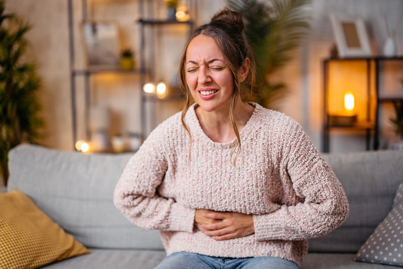 Mid-adult woman having a stomachache at home.