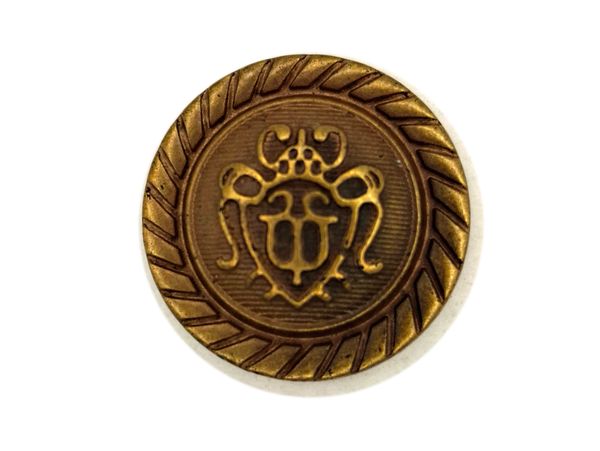 Antique brass button with intricate emblem and rope-like border design.