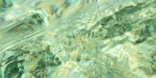 Clear water surface with underwater rocks.