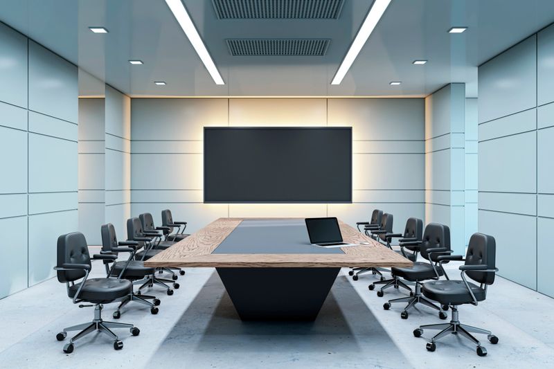 Contemporary meeting room with wooden table, chairs, backlit screen. Minimalist walls and lighting. Concept of modern corporate workspace. 3D Rendering.