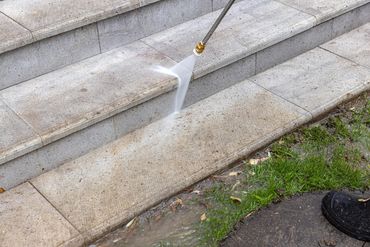 Power washing dirty stone steps to clean them.