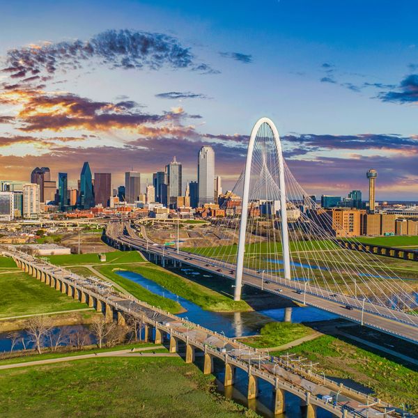 Dallas skyline with Margaret Hunt Hill Bridge at sunset.