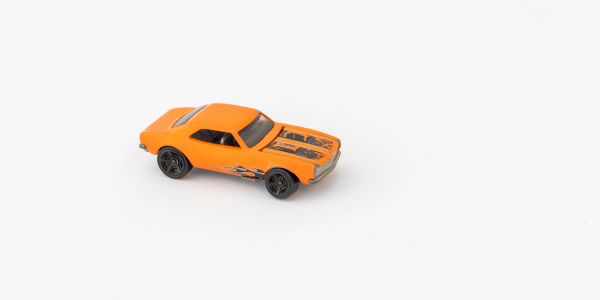 Orange toy car on a white surface.