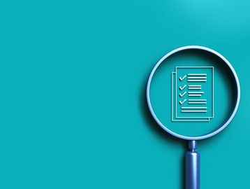 Magnifying glass highlighting a checklist on a blue background.