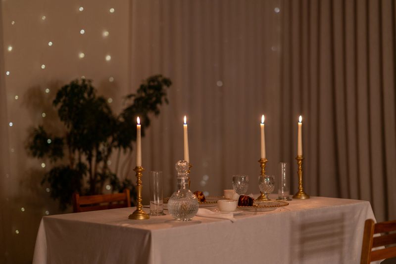 Elegant table setting for a romantic dinner, illuminated by candlelight, creating a warm and inviting atmosphere