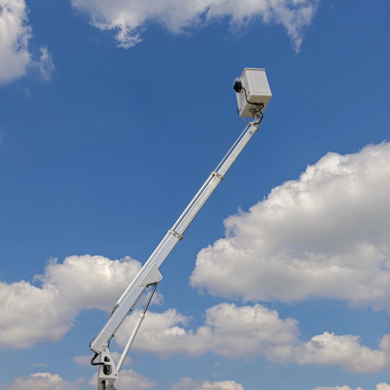 Long Boom Hydraulic Telescopic Aerial Work Platform High in Clouds Sky