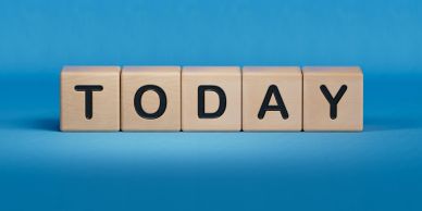 Wooden blocks spelling out TODAY on a blue background.