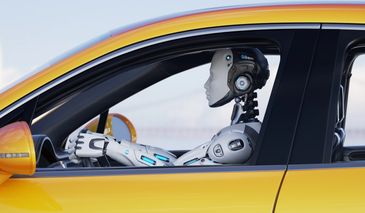 A humanoid robot driving a yellow car, looking ahead attentively.