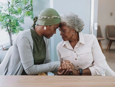 Two women share a tender moment holding hands.