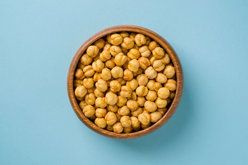 Top view of yellow roasted chickpeas in wooden bowl