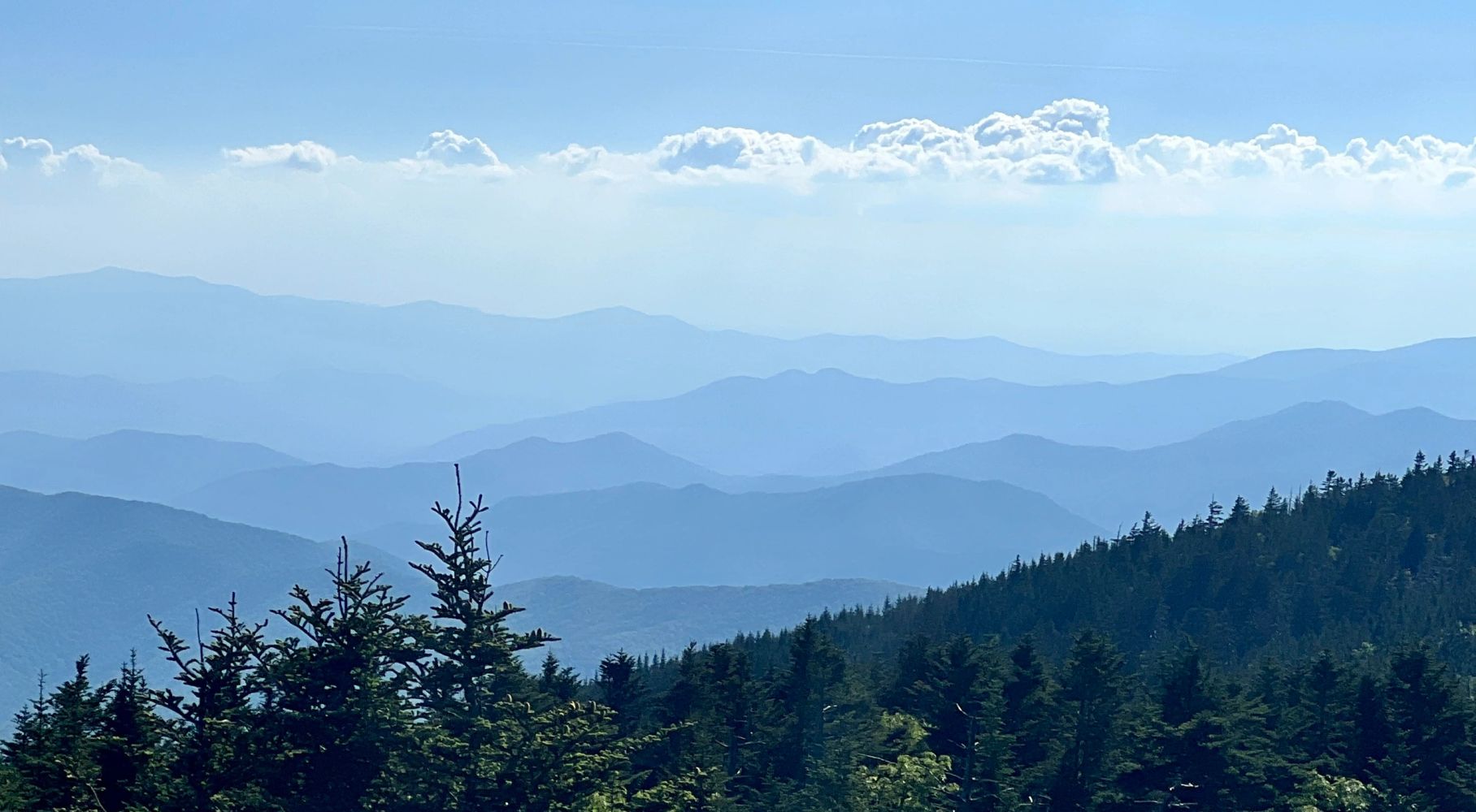 Layers of blue mountains fading into the distance under a bright sky.