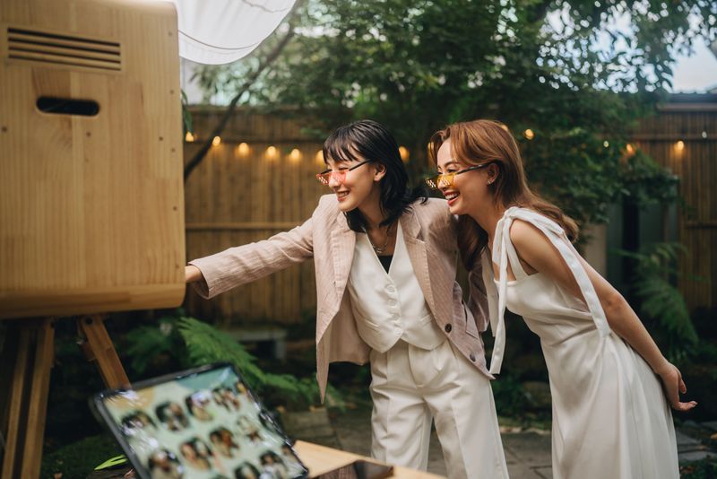 Lesbian bride and groom enjoy the photo booth and take awesome wedding photos together.