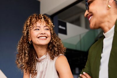 Two women sharing a joyful moment during a conversation.