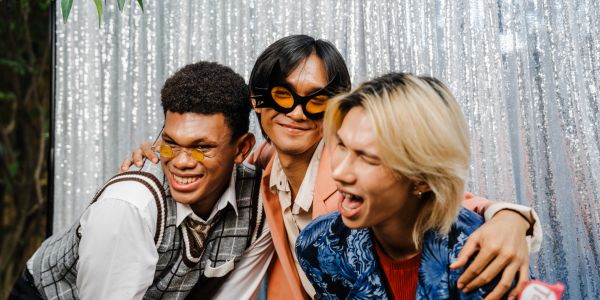 Three friends having fun with sunglasses and smiles.