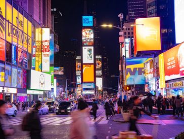 Busy night in Times Square with bright billboards.