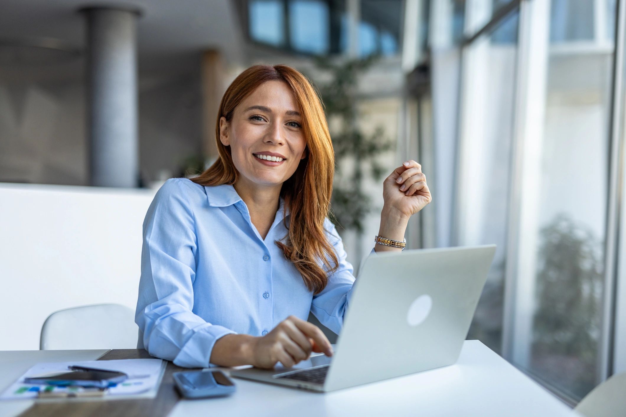 Business person smiling with a laptop in front of them
