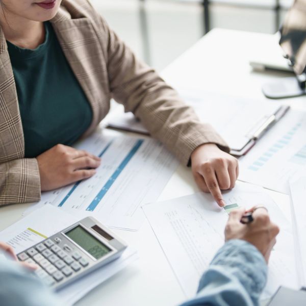 People discussing financial documents with a calculator.