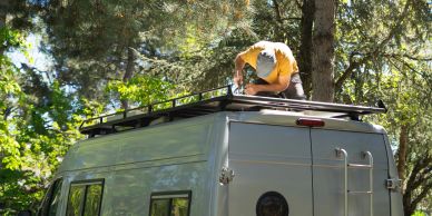 Person working on roof rack of a van.