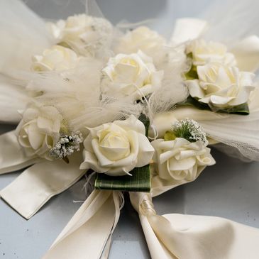 A bouquet of white roses with soft tulle and satin ribbons.