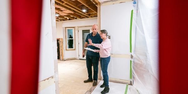 Two people discussing renovations in a room.