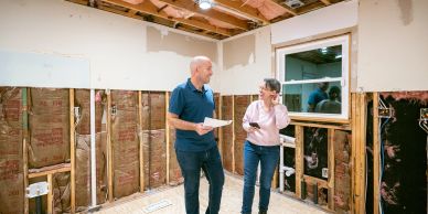 Two people inspecting a room under renovation.
