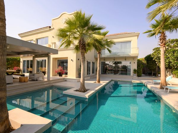 Modern house with a pool and palm trees.