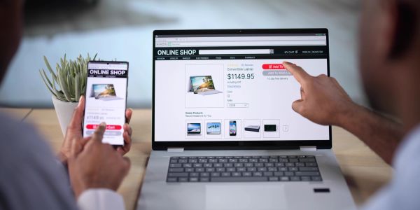 Person shopping online on laptop and smartphone.