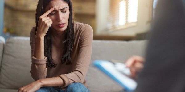 Woman looking stressed during a therapy session.