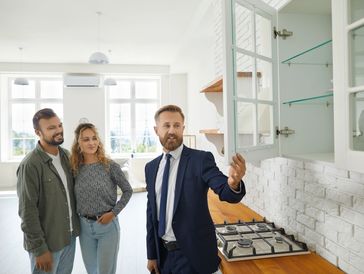 A man in a suit and tie standing next to two women.