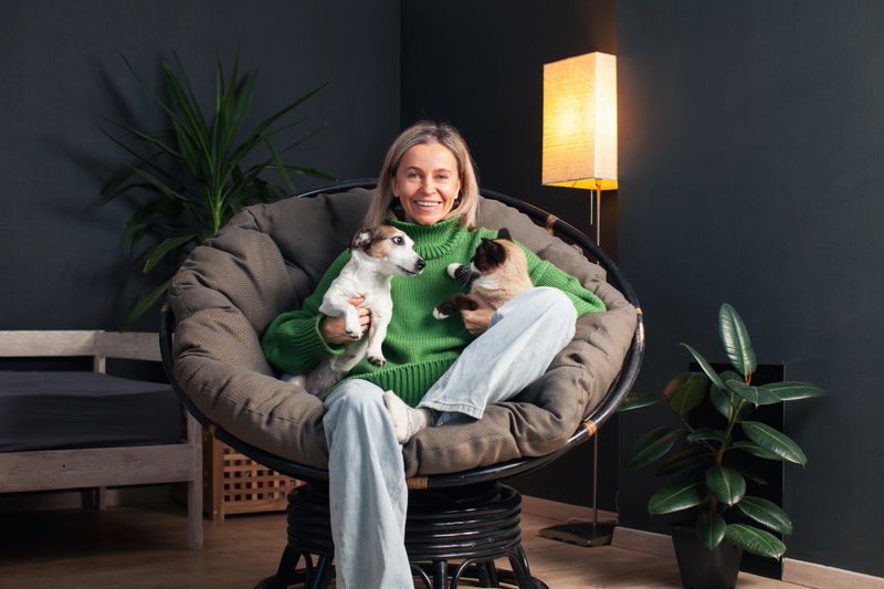 Happy Middle Age Woman Spending day with her Dog and Cat at Home. People and pet embracing and hugging