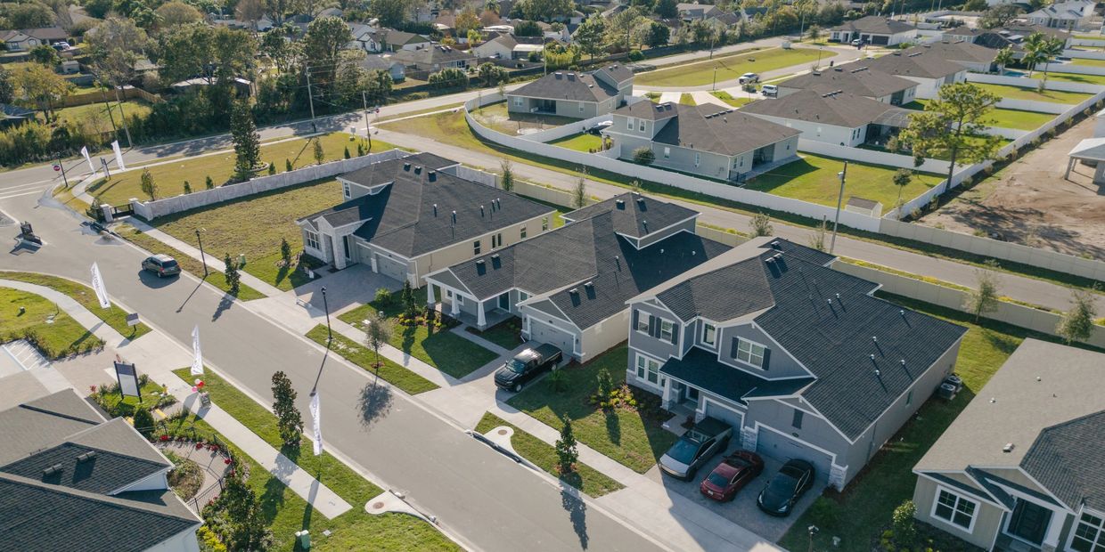 Aerial view of a suburban neighborhood with modern houses and cars parked in driveways.