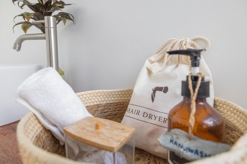 Cozy wicker basket with hair dryer, towel, and amenities. Elegant spa essentials on wooden tray. Perfect for hotels, spas, and wellness centers.